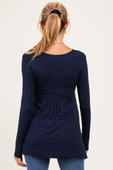 woman wearing a navy blue long sleeve maternity top with a gathered back design