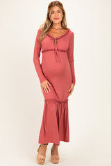 woman wearing a dusty rose maternity maxi dress with ruffle details and a baby bump visible