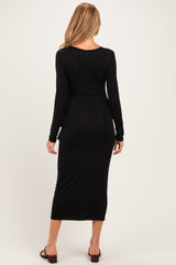 woman wearing a black long sleeve maternity dress with a fitted silhouette, showing a smooth back view