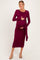 woman wearing a burgundy long sleeve maternity dress with a tied waist holding her baby bump