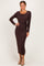 woman wearing a brown long sleeve wrap dress with a side tie and a midi length, standing with one hand on her hip