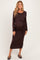 woman wearing a dark brown maternity dress with a side tie detail and long sleeves, showcasing her baby bump