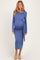 woman wearing a blue long sleeve maternity dress with a tied waist and visible baby bump