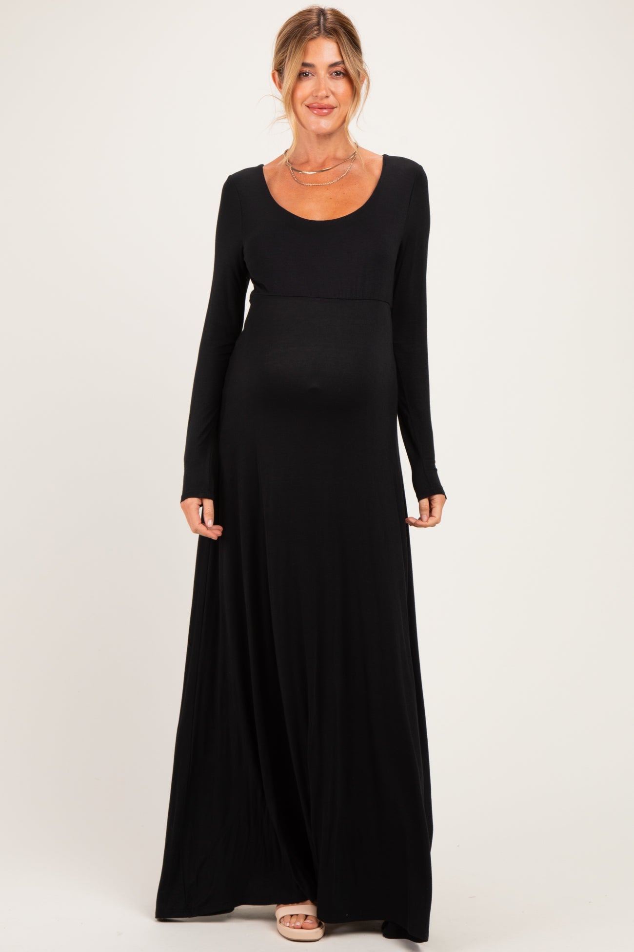 woman wearing a black long sleeve maternity maxi dress with a scoop neckline and baby bump visible