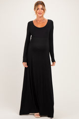 woman wearing a black long sleeve maternity maxi dress with a scoop neckline and baby bump visible