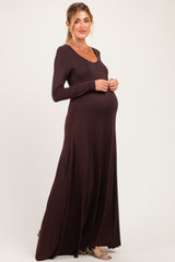 woman wearing a dark brown long sleeve maternity dress and showing her baby bump