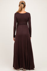 woman wearing a dark brown long sleeve maternity dress with a flowing skirt, showing a smooth back design
