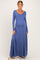 woman wearing a long sleeve blue maternity maxi dress with a fitted bodice and flowing skirt, showing her baby bump
