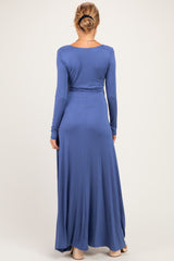 woman wearing a long sleeve blue maternity maxi dress, showing the back view