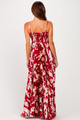 woman wearing a red floral maxi dress with a smocked back and pleated skirt