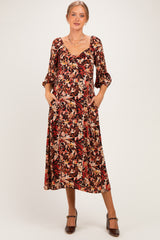 woman wearing a floral print maternity midi dress with three-quarter sleeves and pockets, showcasing her baby bump