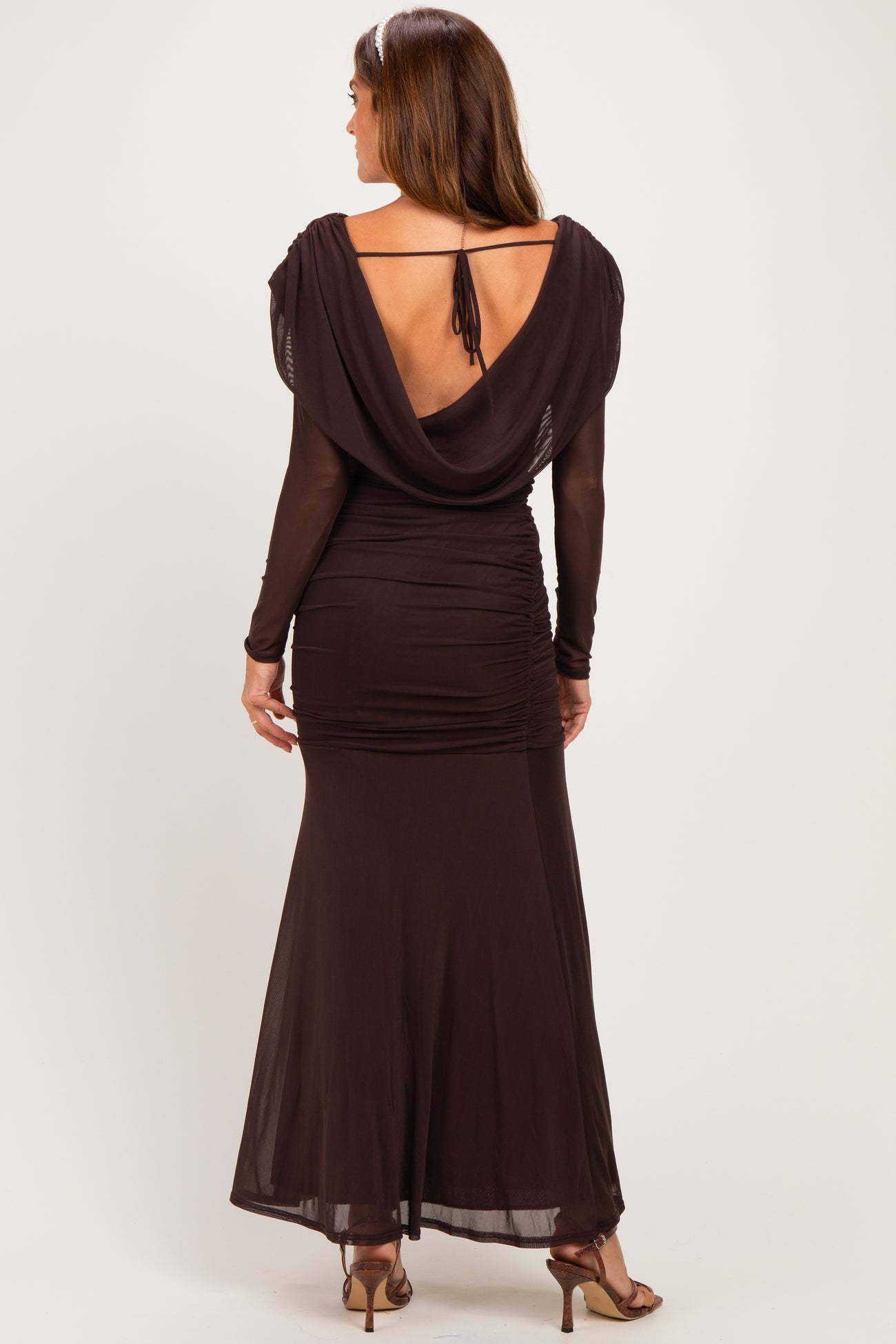 woman wearing a dark brown long sleeve maxi dress with a draped back and ruched detailing