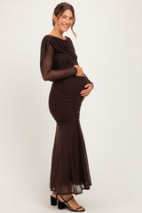 woman wearing a long sleeve brown maternity gown with ruching and a flared skirt, holding her baby bump