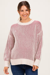 woman wearing a striped maternity sweater in cream and burgundy with balloon sleeves and a relaxed fit