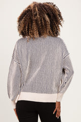 woman wearing a striped maternity sweater with wide sleeves and a relaxed fit, seen from the back