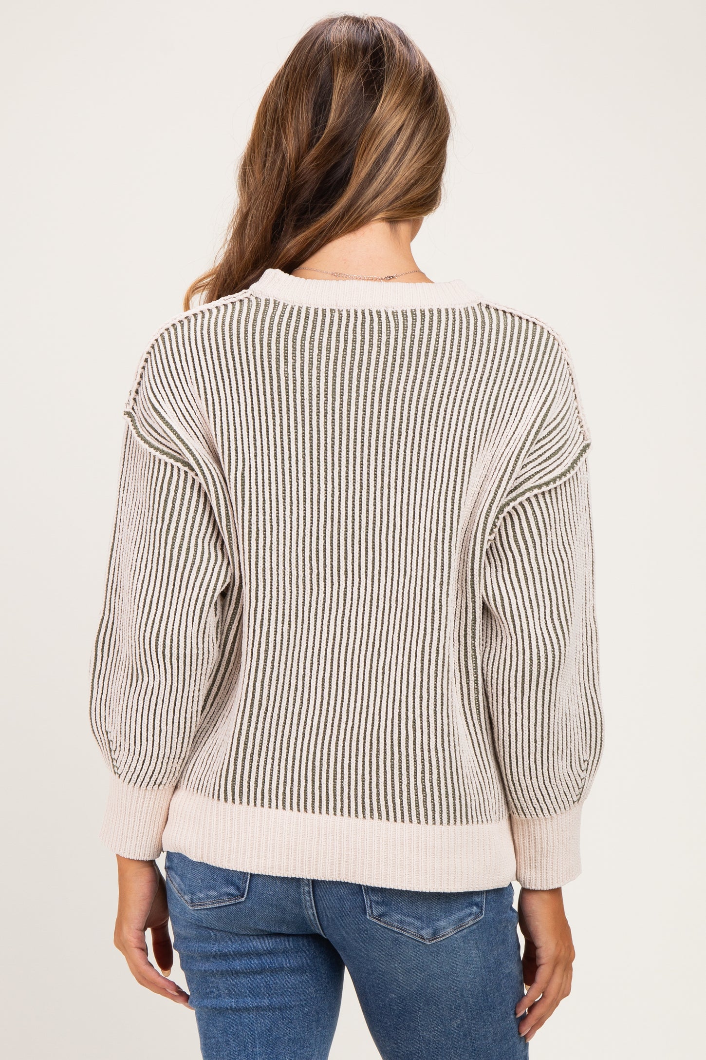 woman wearing a striped maternity sweater with oversized sleeves, shown from the back