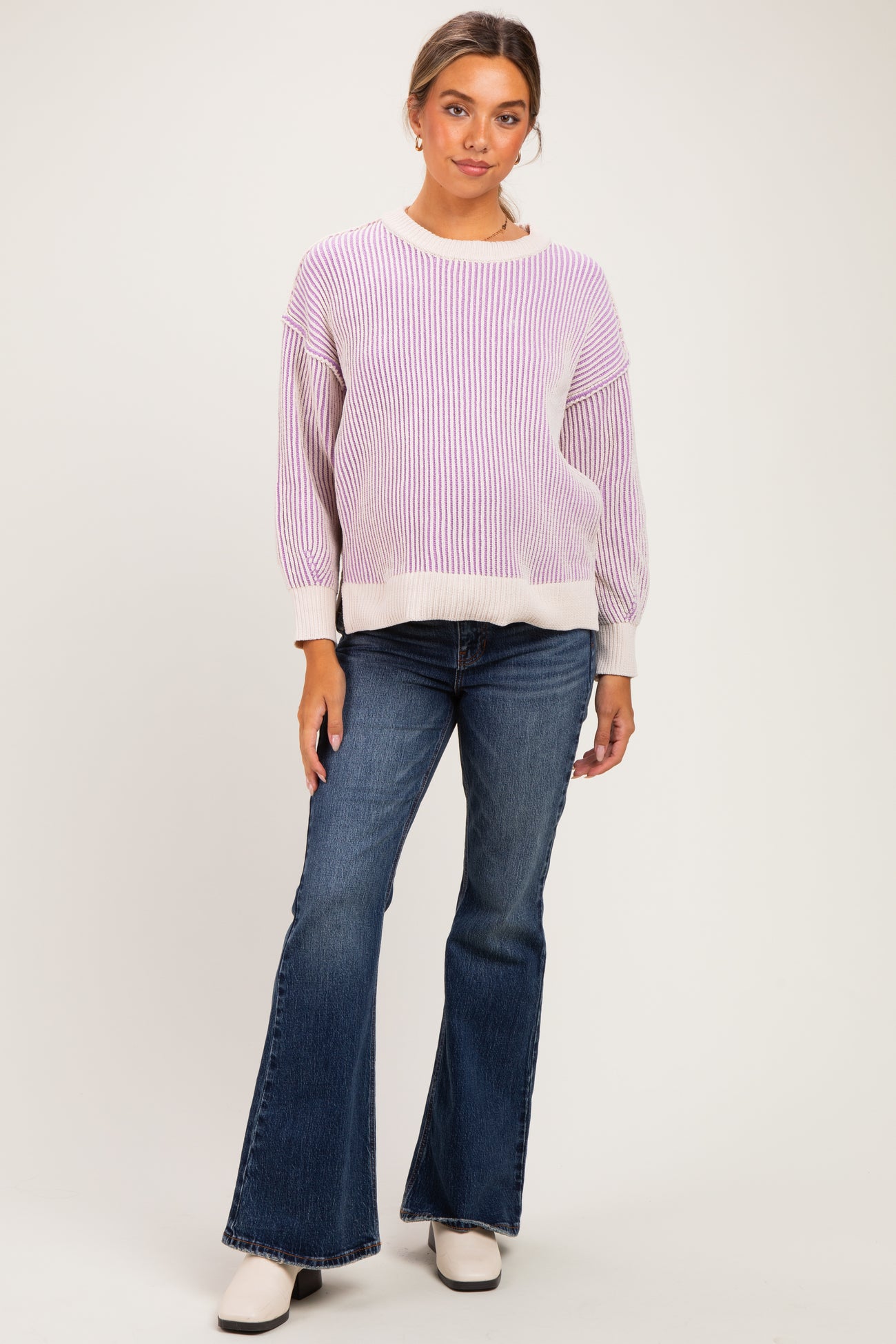 woman wearing a lavender striped maternity sweater and flared jeans, with a relaxed fit and long sleeves
