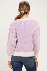 woman wearing a striped lavender and cream maternity sweater with balloon sleeves and a relaxed fit, seen from the back