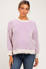 woman wearing a striped light purple and beige maternity sweater with relaxed fit and balloon sleeves