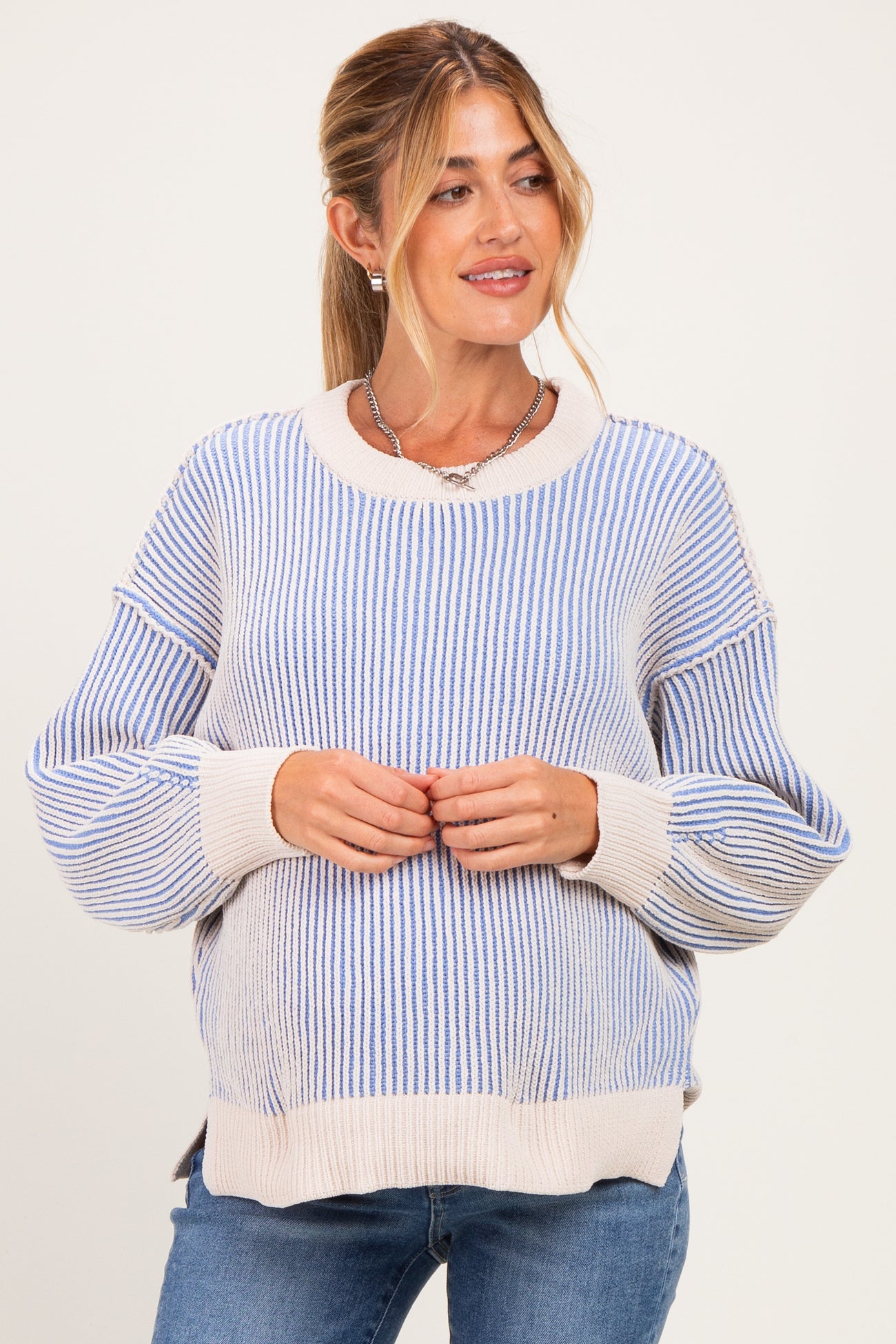 woman wearing a blue and white striped maternity sweater with a visible baby bump