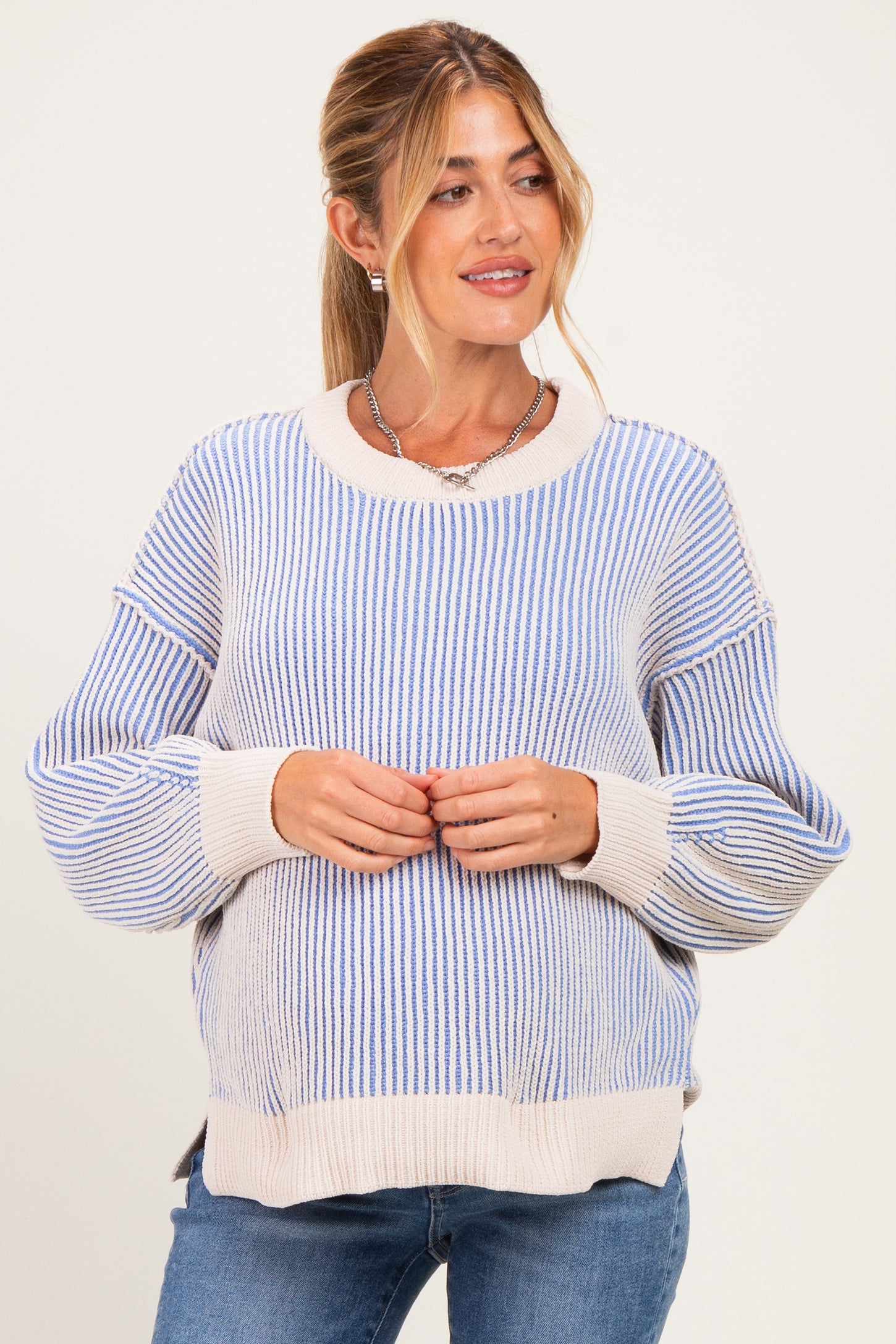 woman wearing a blue and white striped maternity sweater with a visible baby bump