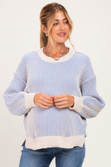 woman wearing a blue and white striped maternity sweater with a visible baby bump