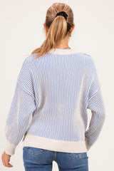 woman wearing a striped maternity sweater in light blue and cream, showing the back view with relaxed fit and dropped shoulders