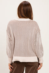 woman wearing a cream and brown striped oversized sweater, showing the back view with balloon sleeves