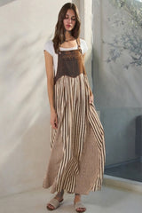 woman wearing a brown striped maxi dress with a fitted bodice and flowy skirt, styled with a white t-shirt underneath