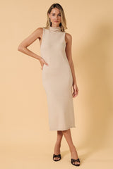 woman wearing a neutral beige sleeveless turtleneck knit midi dress with a relaxed fit and side slits