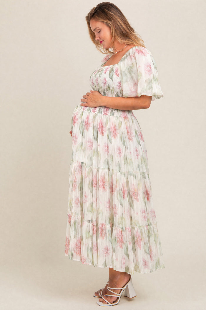 woman wearing a floral print maternity maxi dress with short sleeves and a baby bump visible