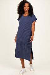 woman wearing a navy blue ribbed midi dress with short sleeves and side slits, styled with white sneakers
