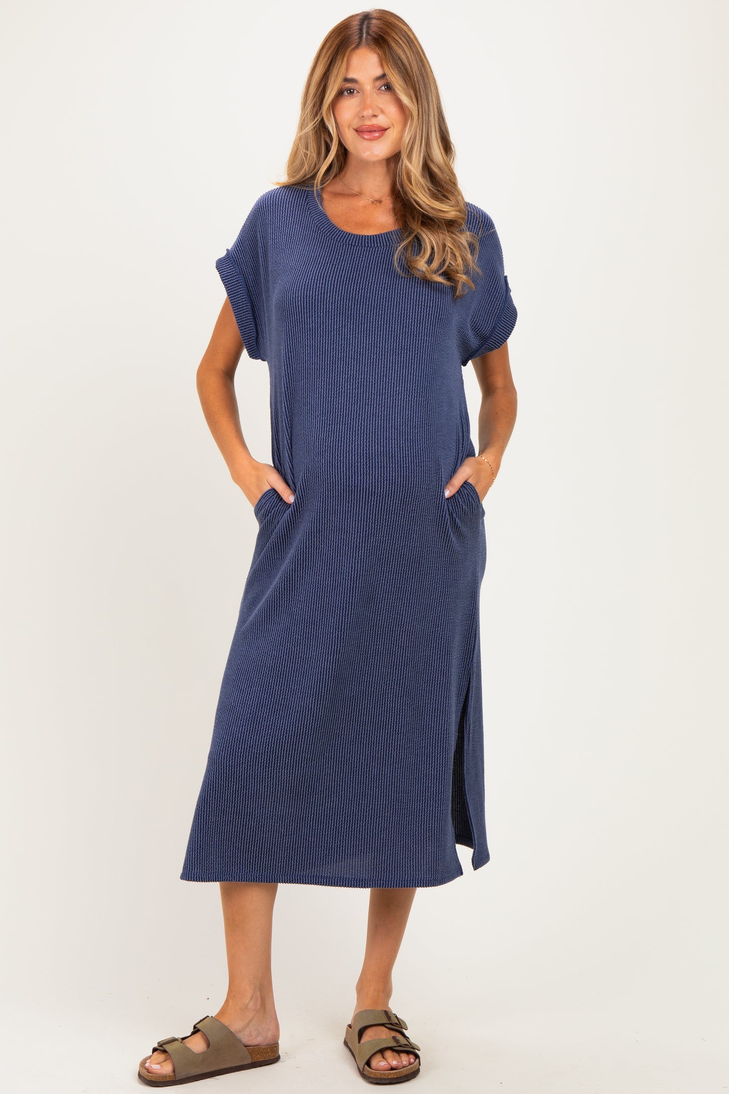 woman wearing a navy striped midi maternity dress with short sleeves and pockets, no visible baby bump