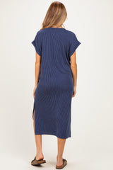 woman wearing a navy blue ribbed maternity maxi dress with side slits and short rolled sleeves, showing a baby bump