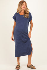 woman wearing a navy blue ribbed maternity maxi dress with rolled sleeves and a side slit