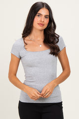 woman wearing a grey short sleeve fitted top with a square neckline and a slight ribbed texture
