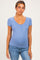 woman wearing a light blue maternity top with short sleeves and button detail, showing her baby bump