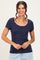 woman wearing a navy short sleeve scoop neck button-up top with a fitted style and smiling