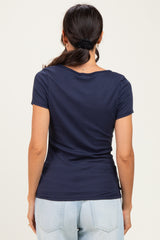 woman wearing a navy blue short sleeve top with a fitted silhouette and scoop neck, viewed from the back
