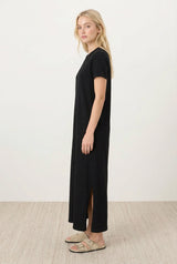 woman wearing a black short sleeve maxi dress with side slits and a relaxed fit