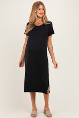 woman wearing a black short sleeve maternity dress with side slits and a visible baby bump