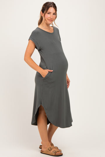 woman wearing a dark gray short sleeve maternity dress with pockets and a baby bump visible