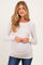 woman wearing a light pink long sleeve maternity top with a gathered side detail and showing her baby bump