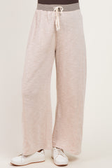 woman wearing light pink wide-leg maternity pants with drawstring waist
