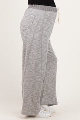 woman wearing gray maternity jogger pants with a drawstring waist and side pockets, showing a baby bump