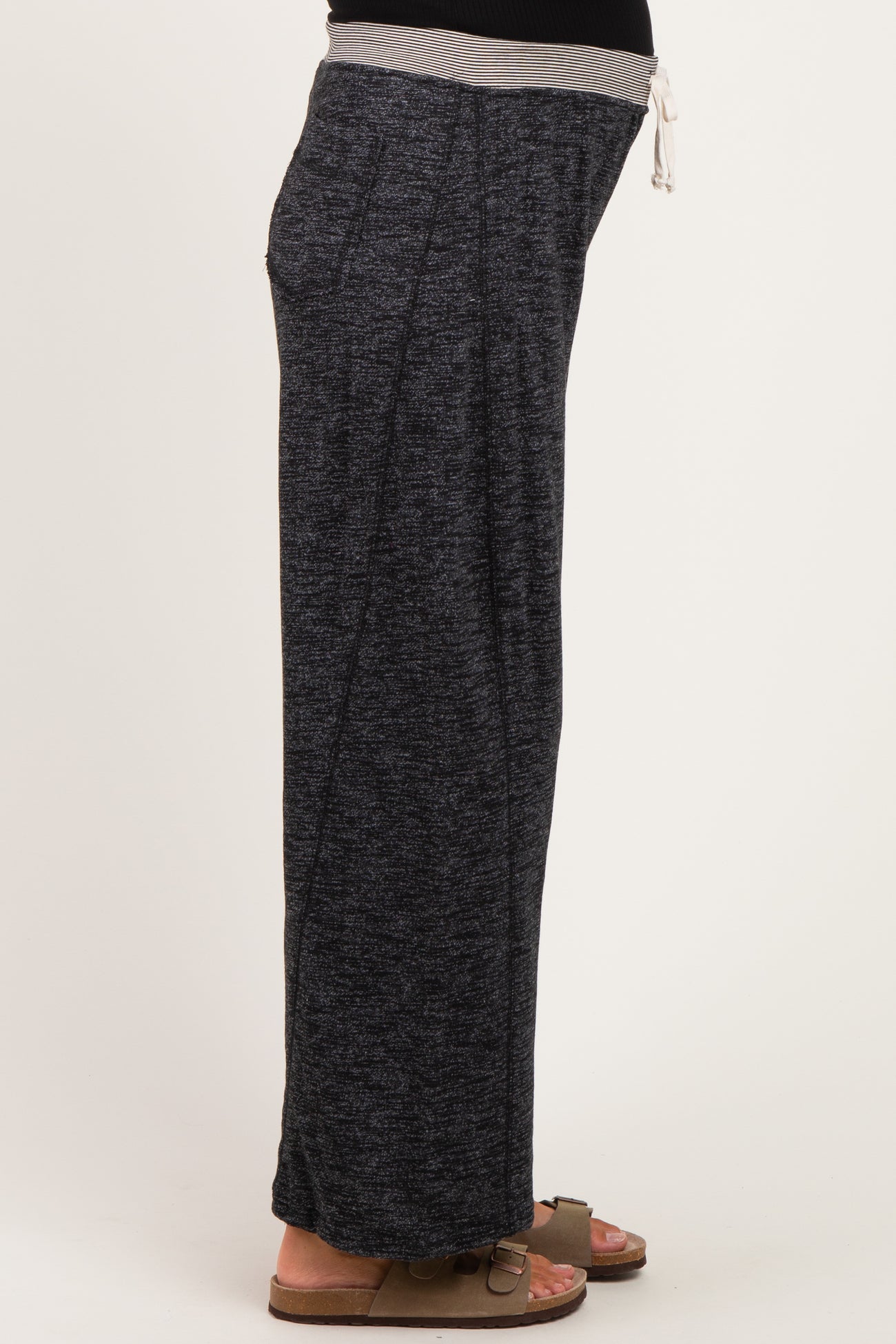 woman wearing dark gray maternity lounge pants with a drawstring waist, showing her baby bump on the side