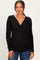 woman wearing a black long sleeve maternity top with a v-neck and fitted style, showing her baby bump