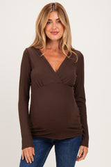 woman wearing a brown long sleeve maternity top with a v-neck and slight ruching at the sides