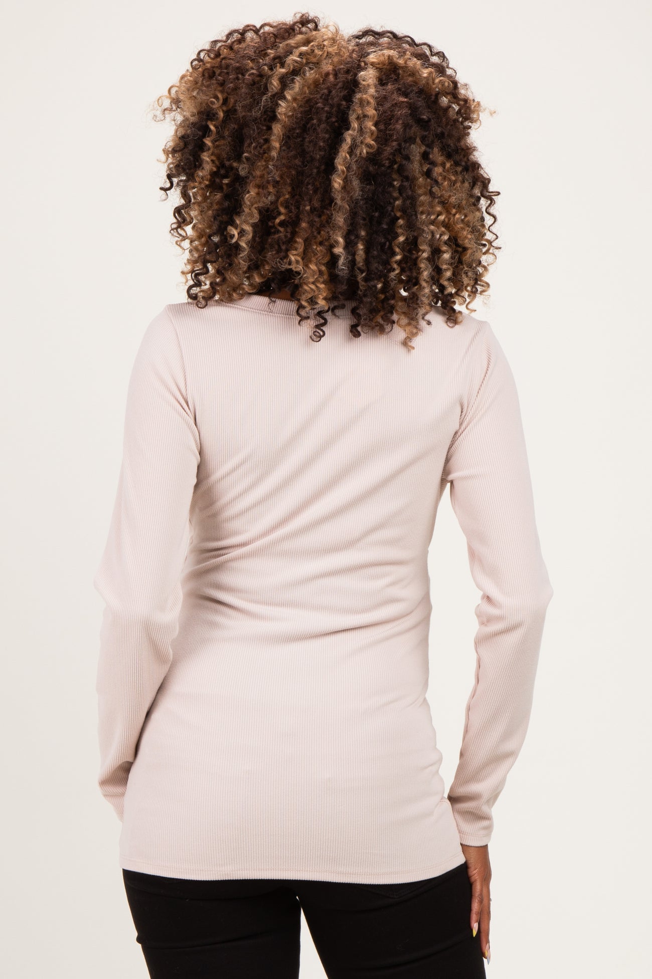 woman wearing a light pink ribbed long sleeve maternity top, showing the back view