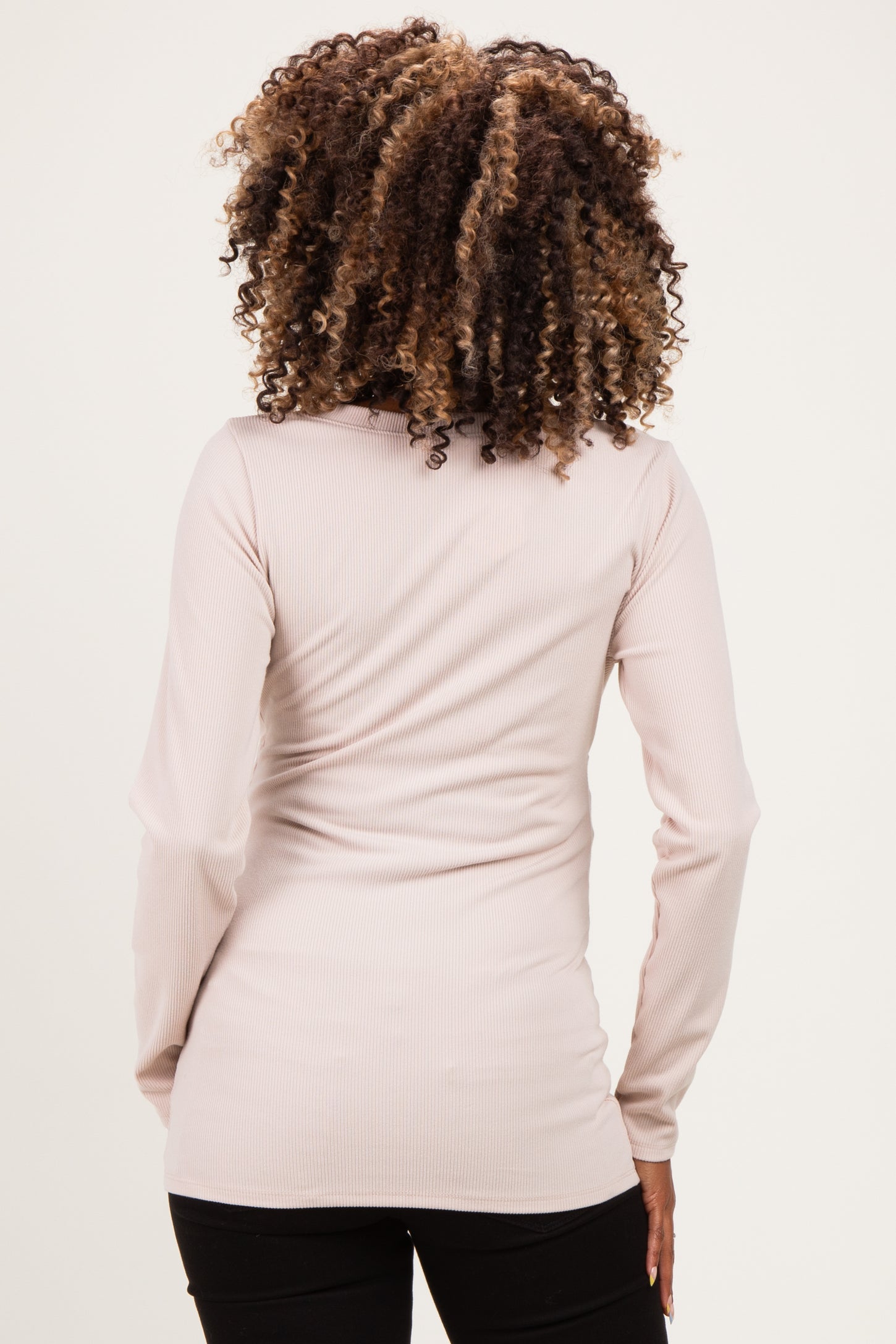 woman wearing a light pink ribbed long sleeve maternity top, showing the back view